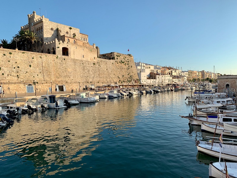 Ein schmaler Hafen, gesäumt von Booten und historischer Architektur.