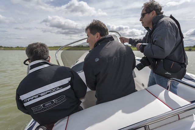 Trois hommes font un test de navigation sur petit bateau à moteur