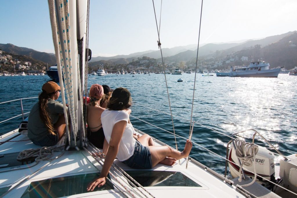 Friends sitting aboard a sailboat in the sunshine