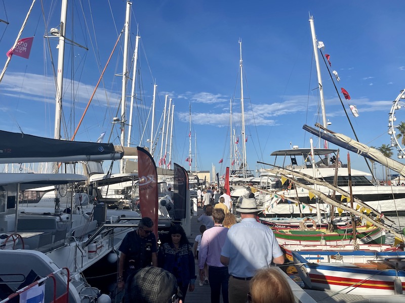 Des visiteurs assistant aux Occasions du Multicoque et du Refit 2023 marchent aux milieu des bateaux dans le port de Canet-en-Roussillon en France.