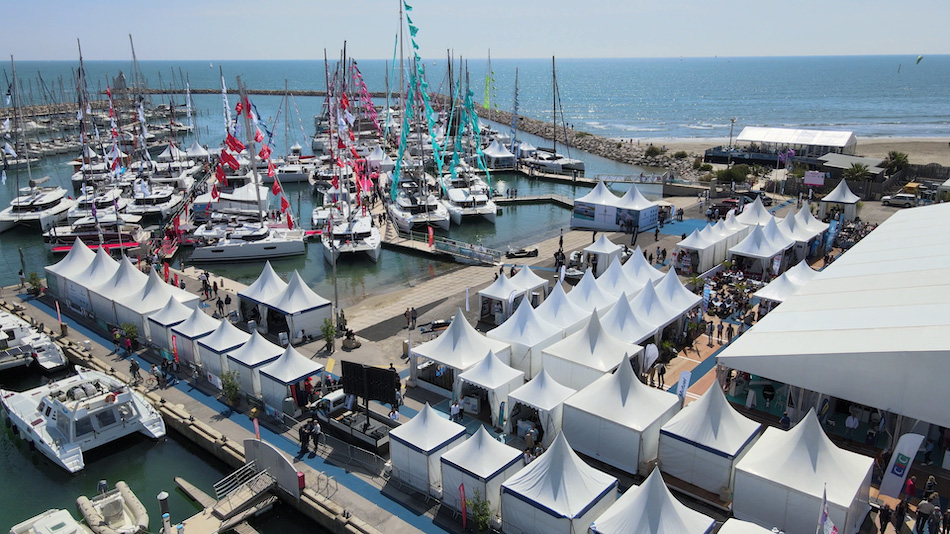 an overhead view of catamarans and trimarans in the port beside the Exhibitor Village at the International Multihull Show in La Grande Motte, France