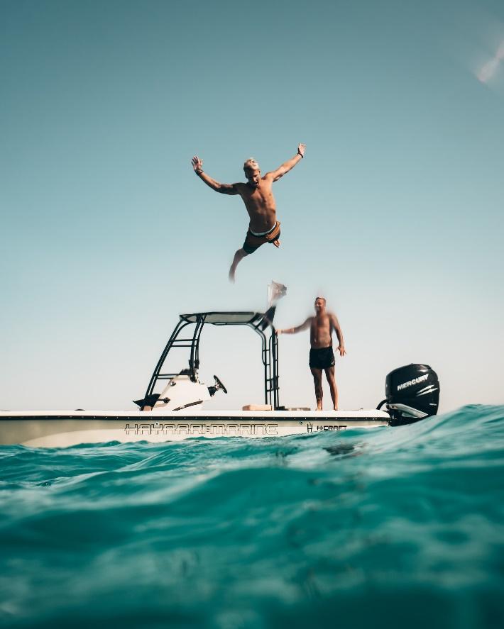 Man jumping off boat into the water