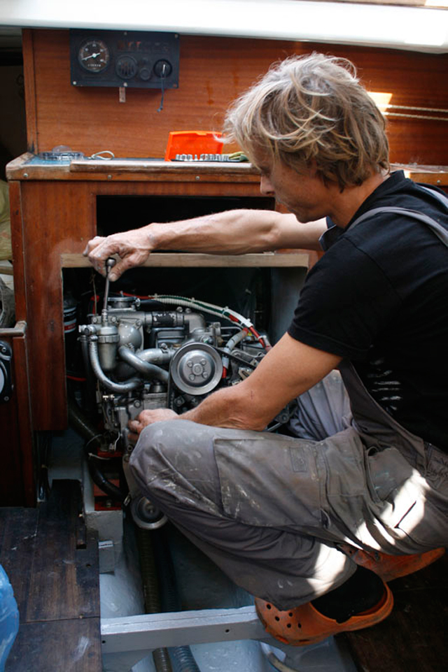 Hombre haciendo mantenimiento de motor en un barco