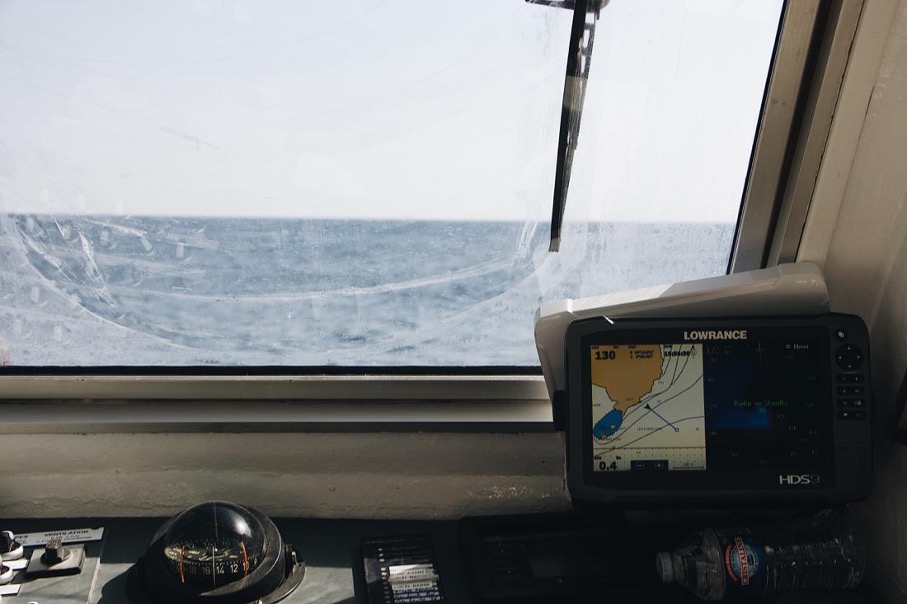 Binnenkant van een boot met navigatieapparatuur en uitzicht op water