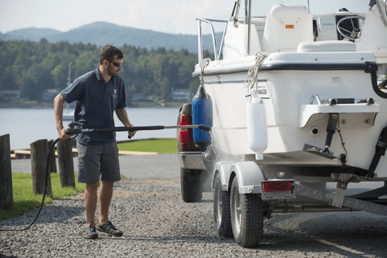 Man maakt boot schoon op het land met hogedrukspuit