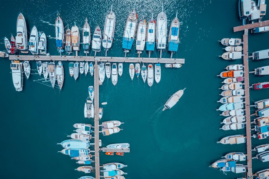 Aerial view of boat navigating a busy harbour.