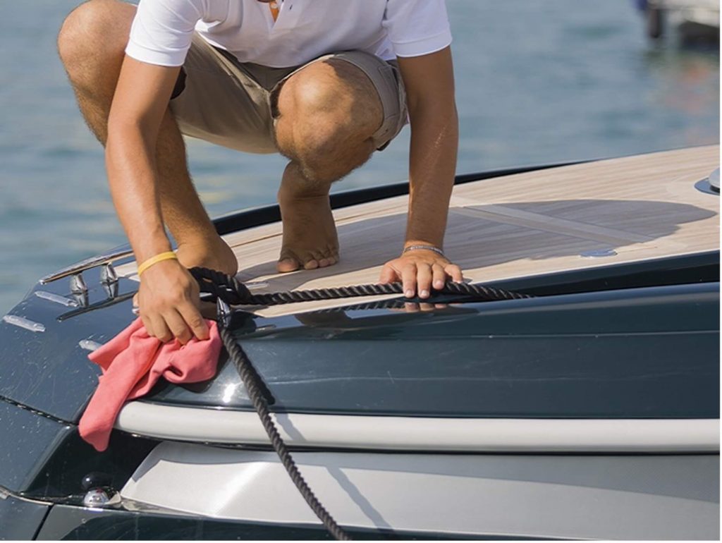 Een man die zijn boot aan het poetsen is