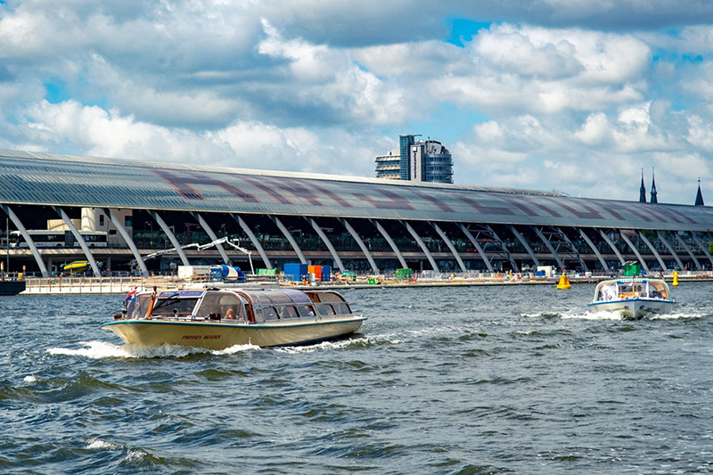 Rondvaartboten in Amsterdam met het Centraal Station op de achtergrond.