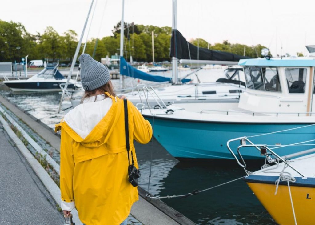 Woman in rain jacket on dock 
