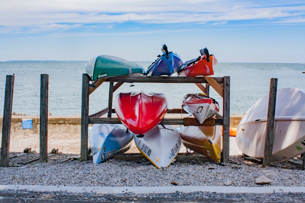 colourful canoes stacked with beach in background