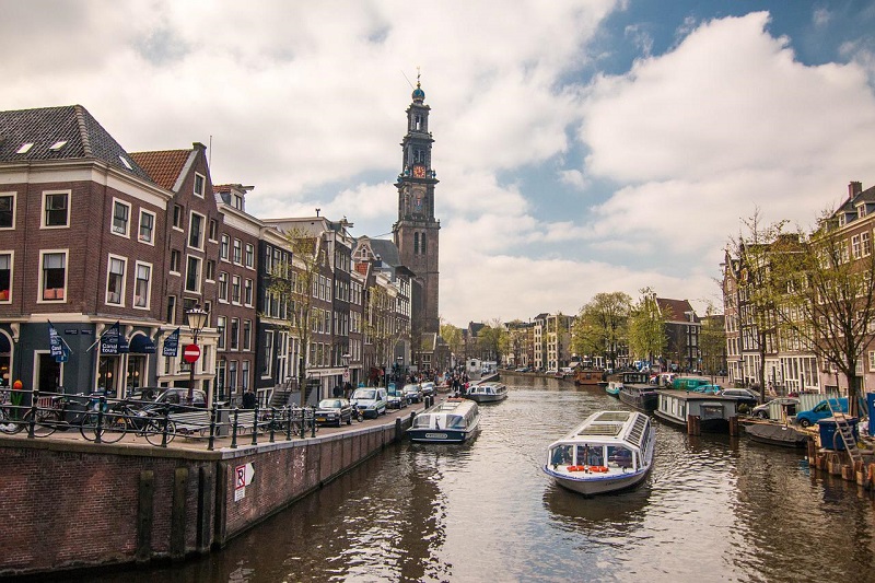 Amsterdamer Grachten mit durchfahrendem Boot.