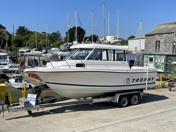 small boat on trailer with for sale sign