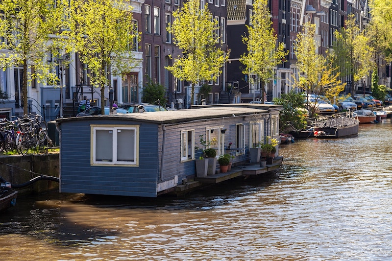 A houseboat painted blue in an Amsterdam canal.