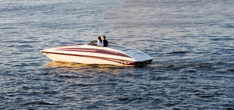 Vrouw en man in een speedboot bij zonsondergang