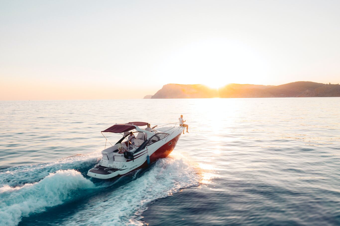 People enjoying a rental boat at sunset