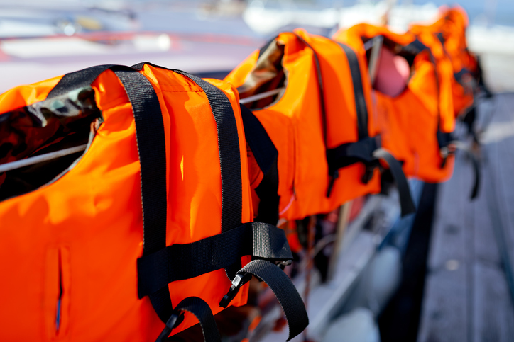 Life jackets hanging outdoors.