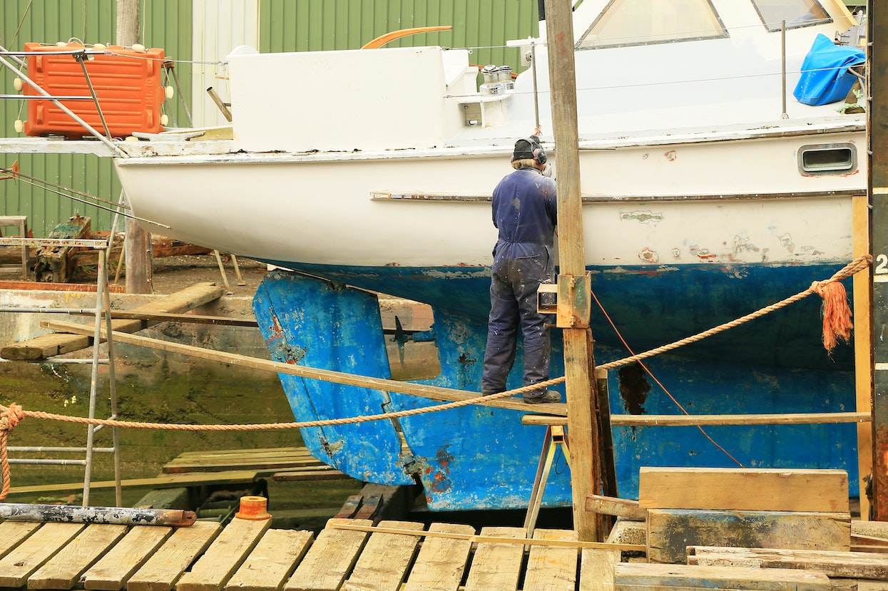 Man reparing a boat in a dry dock