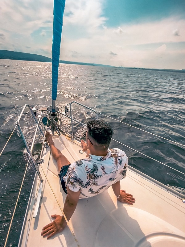 Junge Person auf einem Boot mit Blick aufs Meer.