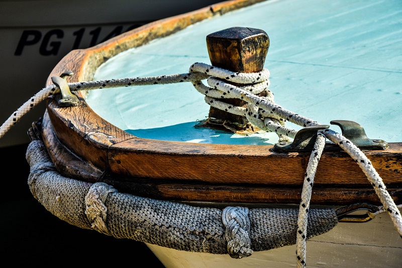 Mooring line tied to a boat with worn wood.