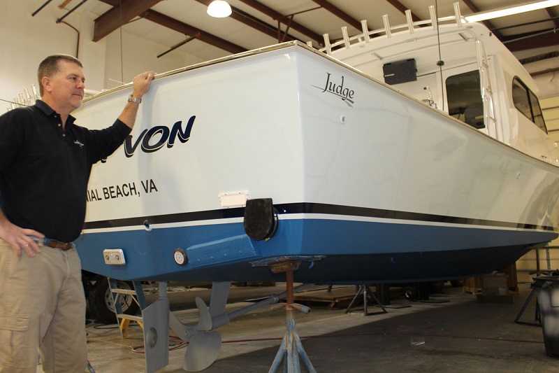 Man standing next to grounded powerboat kept inside.