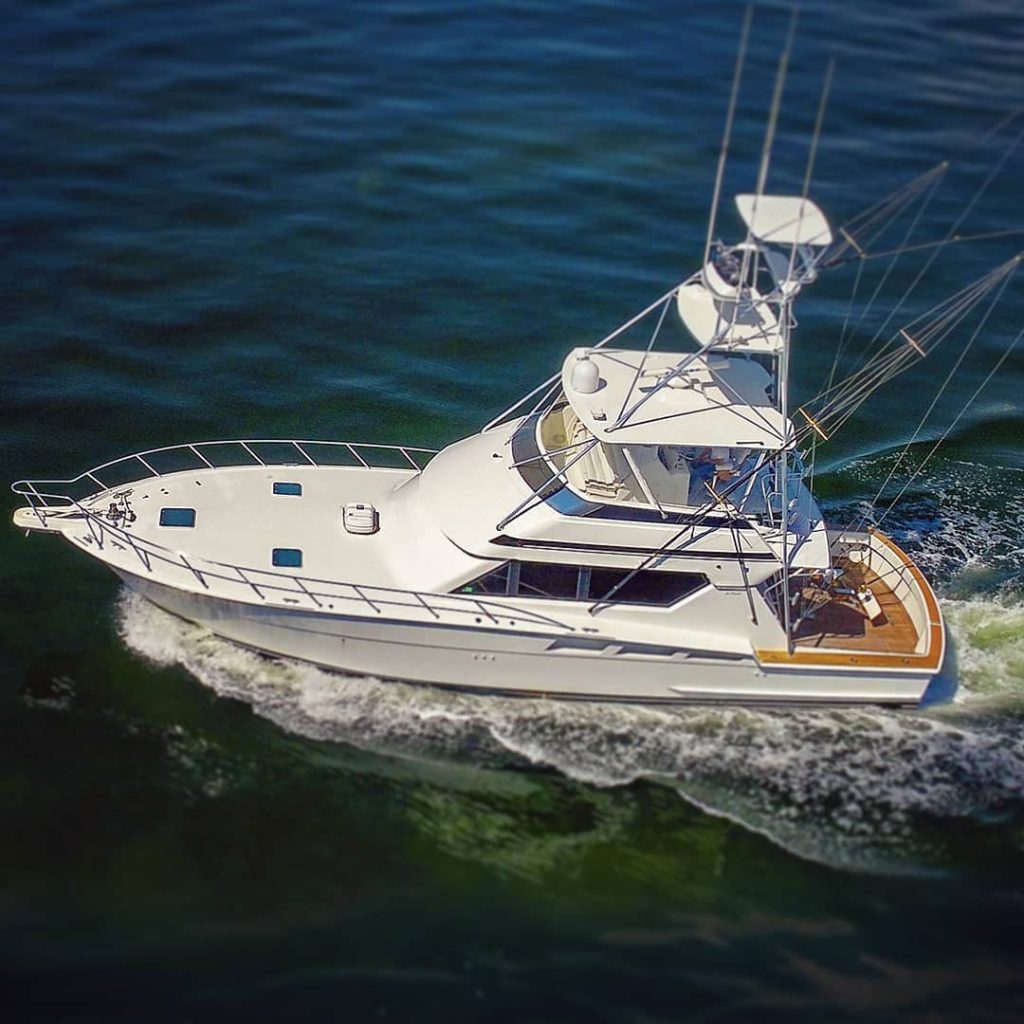 A bird's eye view of a sportfishing yacht moving through the water.